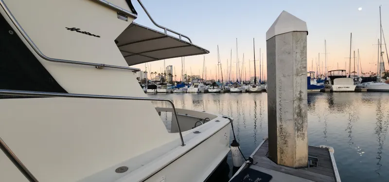 Slide: The Image of 1978 Hatteras Sportfish yacht docked at marina during sunset, surrounded by sailboats. - 9