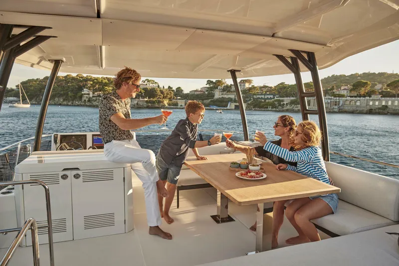 Slide: The Image of Family enjoying drinks on a 2024 Prestige M48 yacht. - 5