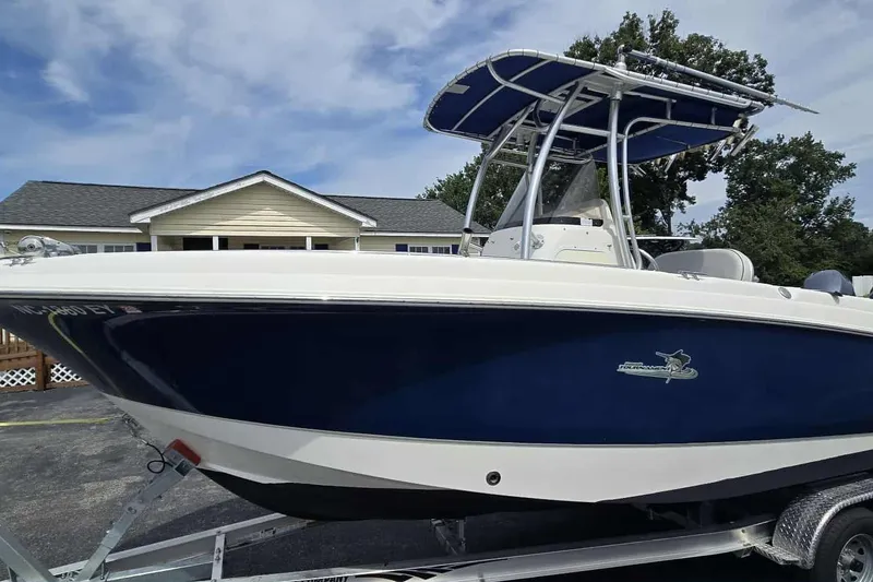 The Image of 2004 Wellcraft 252 Fisherman boat with blue hull on trailer, parked near house. - 0