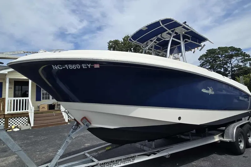 Slide: The Image of 2004 Wellcraft 252 Fisherman boat on trailer, blue hull, parked near house. - 1