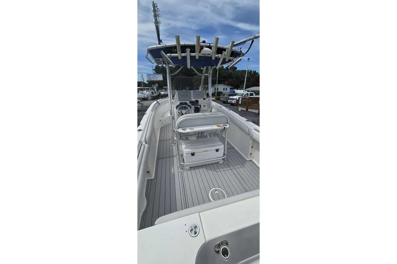 Slide: The Image of 2004 Wellcraft 252 Fisherman boat with center console and rod holders, docked outdoors. - 13
