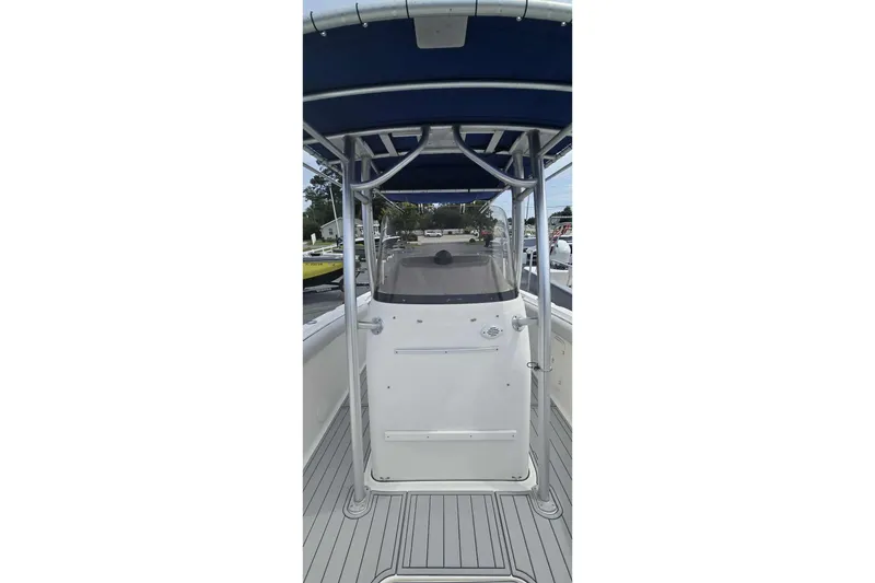 Slide: The Image of 2004 Wellcraft 252 Fisherman boat with blue canopy and sleek design. - 14