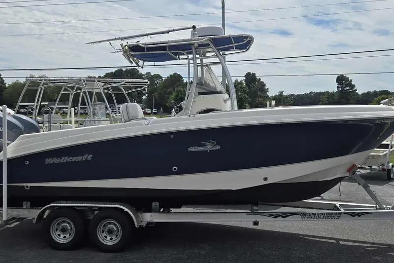 Slide: The Image of 2004 Wellcraft 252 Fisherman boat on trailer, blue and white design, parked outdoors. - 4