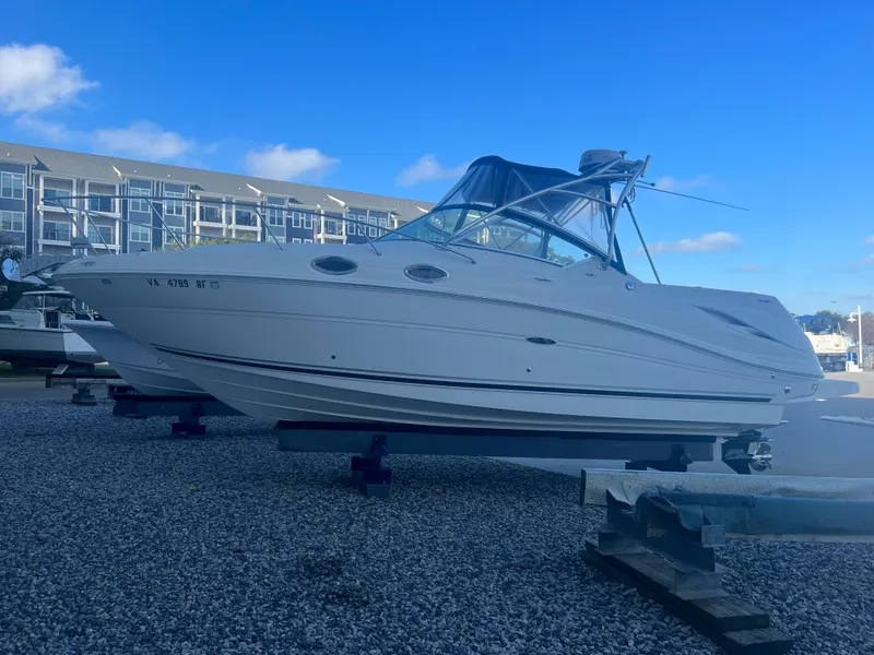 Slide: The Image of 2005 Sea Ray 270 Amberjack boat on gravel lot with blue sky background. - 27