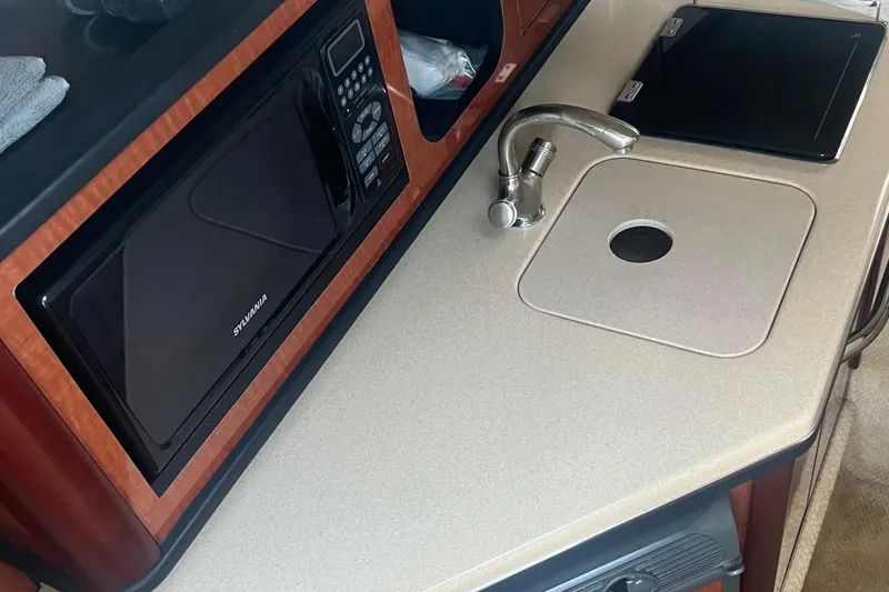 Slide: The Image of 2005 Sea Ray 270 Amberjack galley with microwave, sink, and countertop. - 40