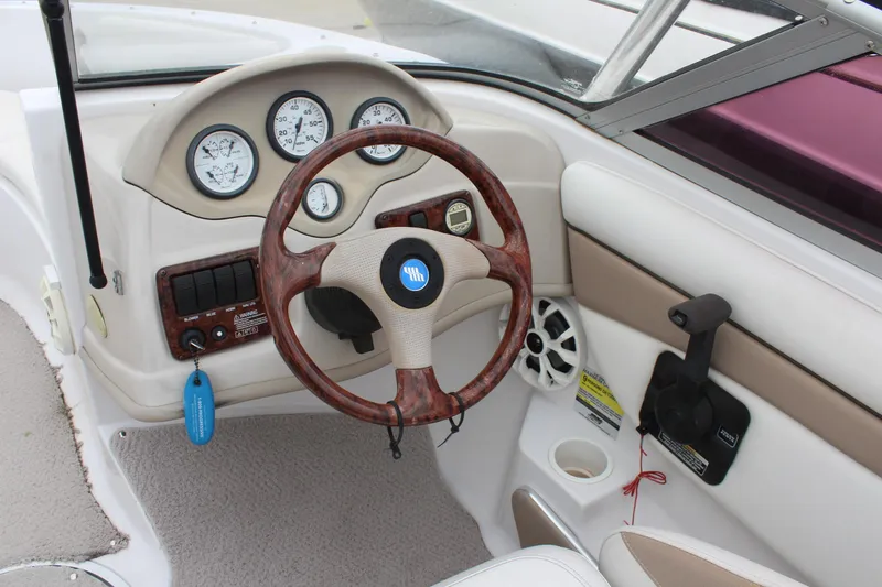 Slide: The Image of 2005 Four Winns HORIZON 200 boat dashboard with wood steering wheel and gauges. - 24