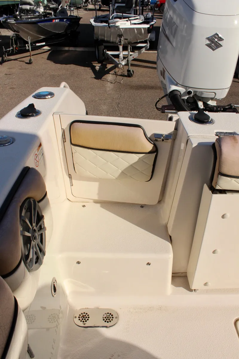 Slide: The Image of 2023 Sea Chaser 27 HFC boat interior with seating and Suzuki outboard motor. - 11
