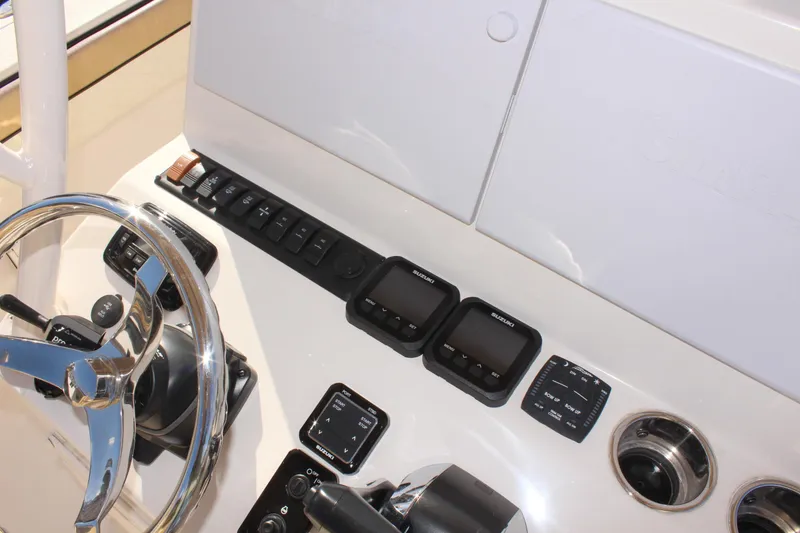 Slide: The Image of 2023 Sea Chaser 27 HFC dashboard with steering wheel and electronic controls. - 27