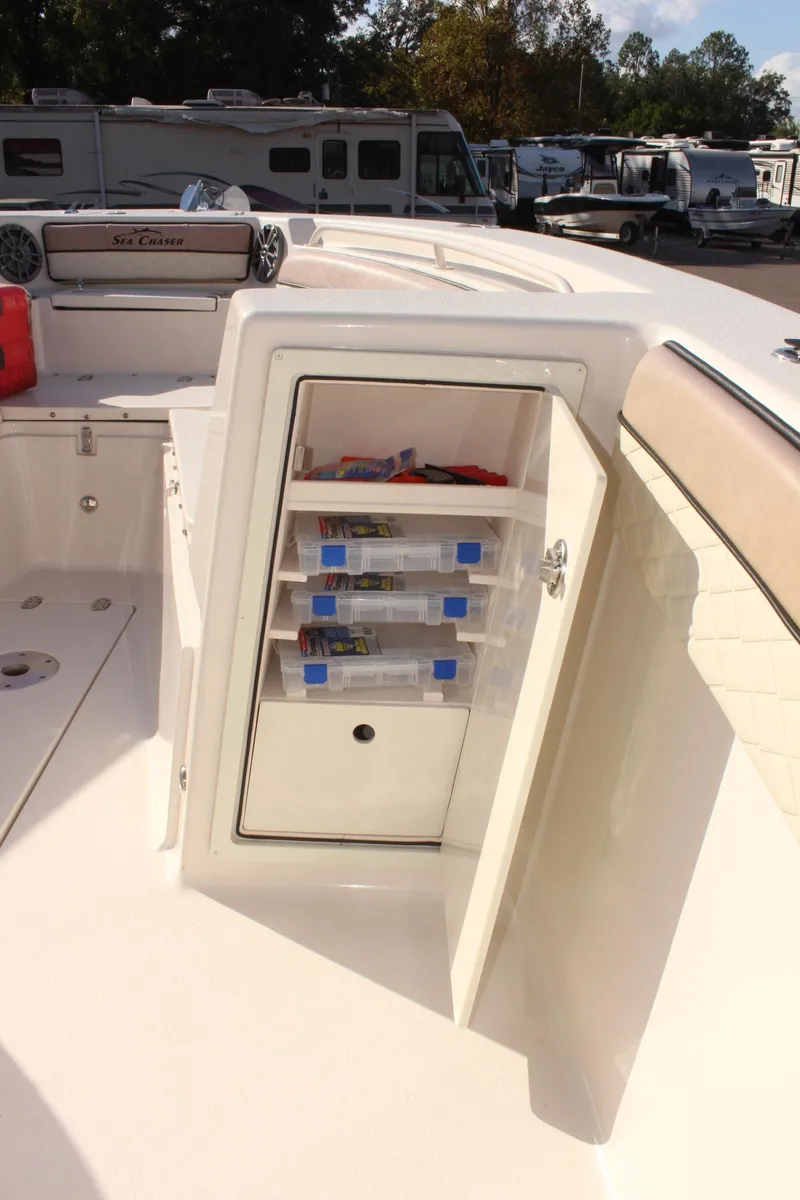 Slide: The Image of 2023 Sea Chaser 27 HFC boat storage compartment with organized shelves. - 29