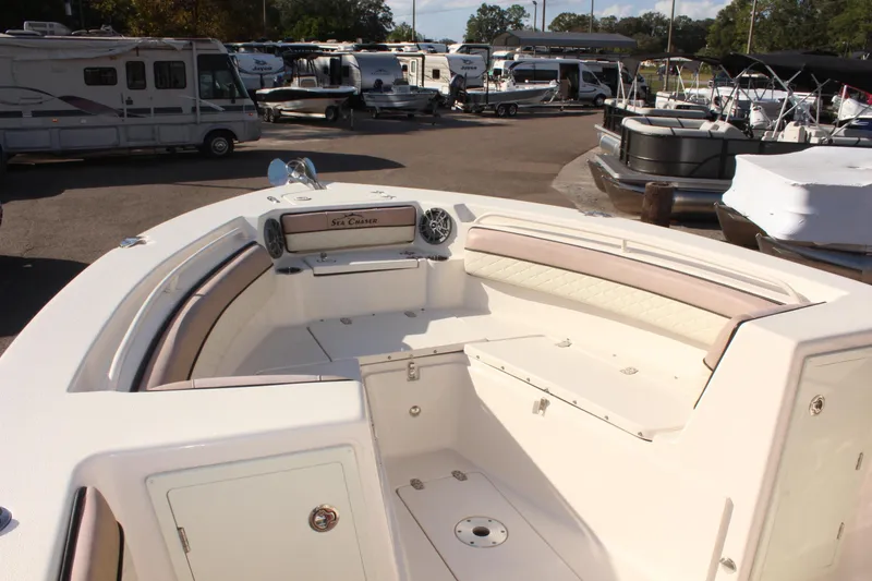 Slide: The Image of 2023 Sea Chaser 27 HFC boat interior with seating and storage, parked in a marina. - 32