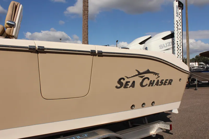 Slide: The Image of 2023 Sea Chaser 27 HFC boat side view with logo, parked on trailer. - 43