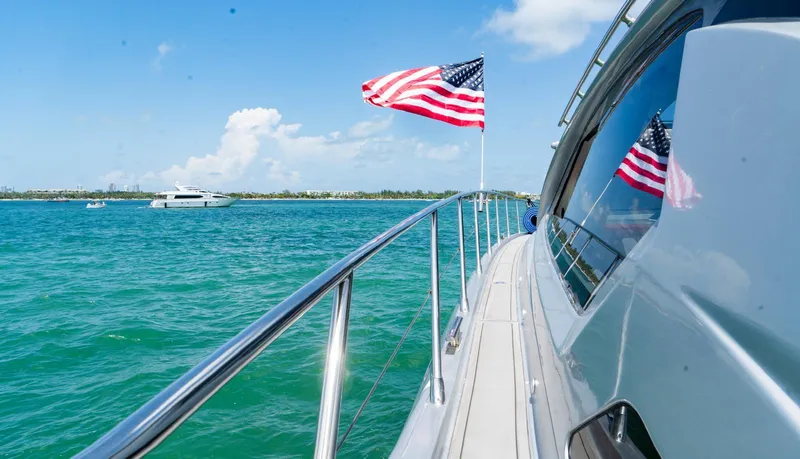 Slide: The Image of Azimut Atlantis 58 yacht cruising with American flag, 2013 model, on clear blue waters. - 12