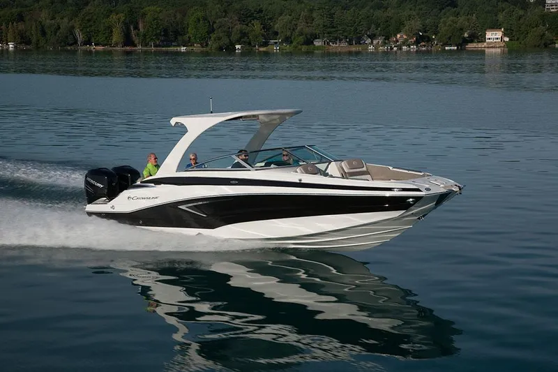 The Image of 2023 Crownline E305XS boat cruising on a lake with passengers. - 0