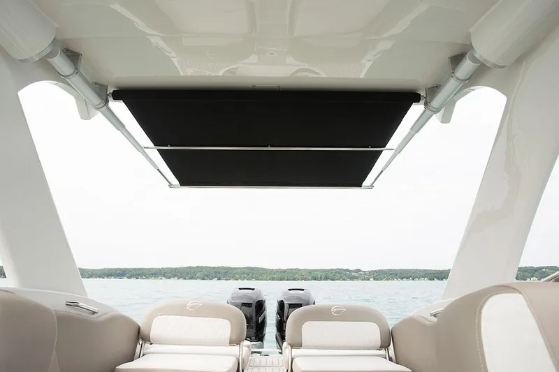 Slide: The Image of 2023 Crownline E305XS boat interior with sunshade and twin engines. - 10
