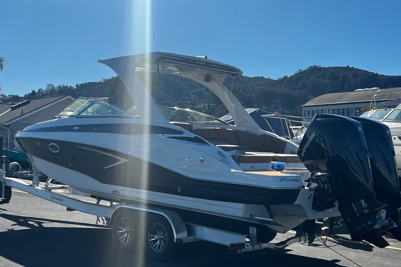 Slide: The Image of 2023 Crownline E305XS boat on trailer in marina. - 4