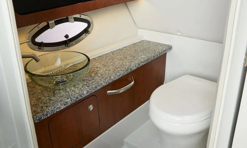 Slide: The Image of 2023 Crownline E305XS boat bathroom with granite countertop and modern fixtures. - 9
