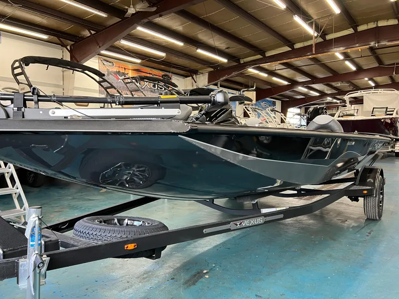 Slide: The Image of 2023 Vexus AVX181 boat on trailer in indoor showroom. - 2