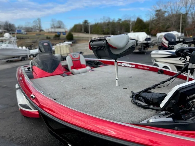Slide: The Image of 2016 Triton 21 TrX bass boat in red, parked outdoors. - 10