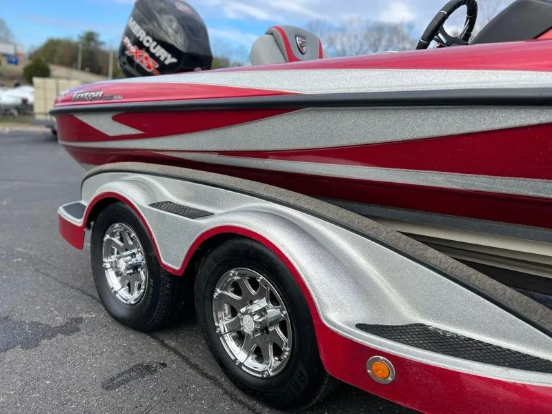Slide: The Image of 2016 Triton 21 TrX boat with red and silver detailing on a trailer. - 4