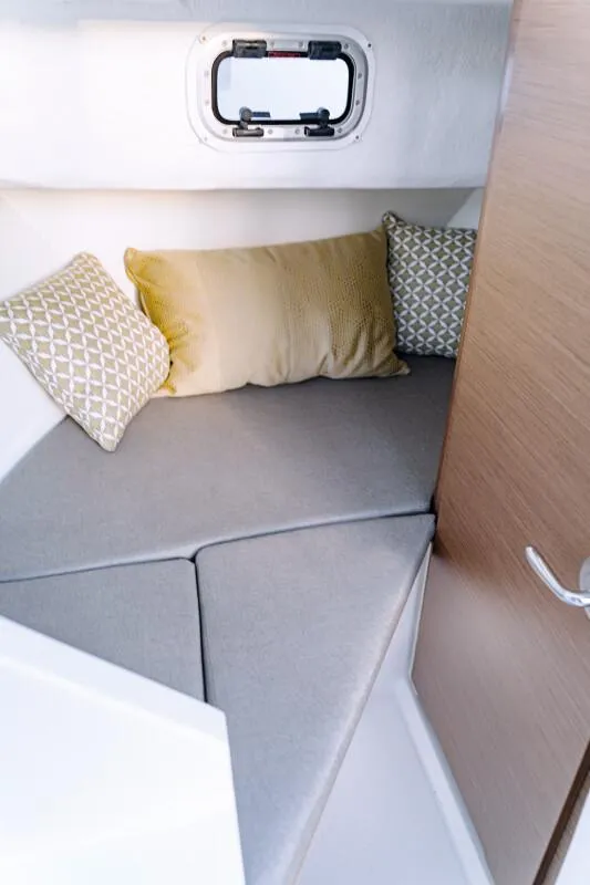 Slide: The Image of 2023 Jeanneau NC 695 Sport S2 cabin interior with cushions and porthole. - 12
