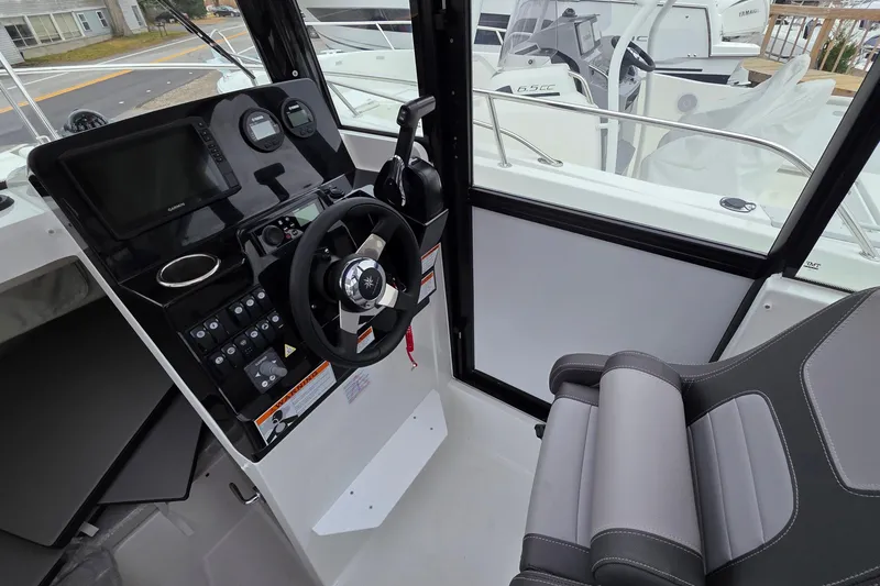 Slide: The Image of 2023 Jeanneau NC 695 Sport Serie 2 cockpit with steering wheel and control panel. - 17
