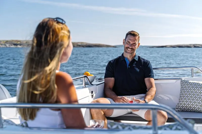 Slide: The Image of 2023 Jeanneau NC 695 Sport S2 boat on a serene lake with paddleboarder. - 5