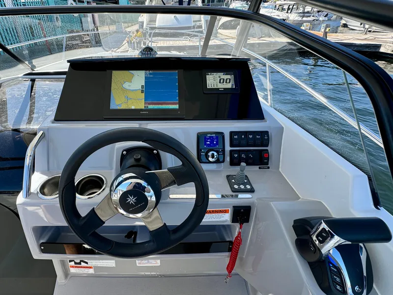 Slide: The Image of 2024 Jeanneau Leader 7.5 WA boat dashboard with steering wheel and navigation display. - 14