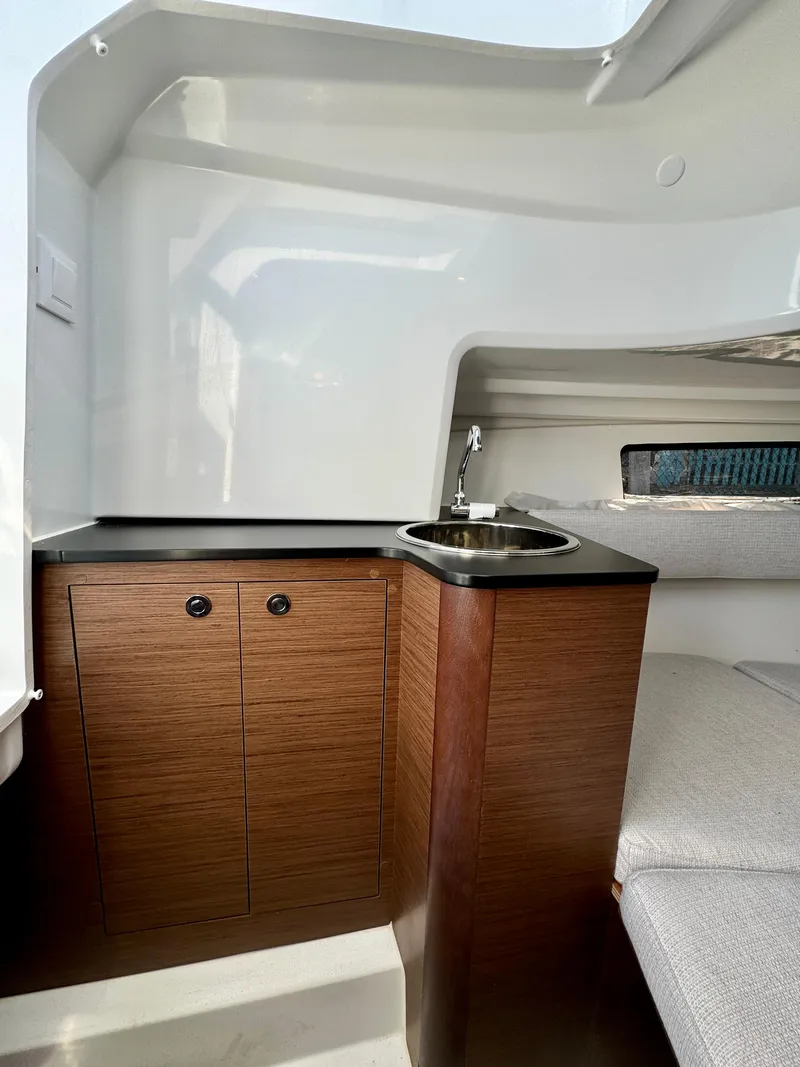 Slide: The Image of 2024 Jeanneau Leader 7.5 WA cabin interior with sink and wooden cabinetry. - 18