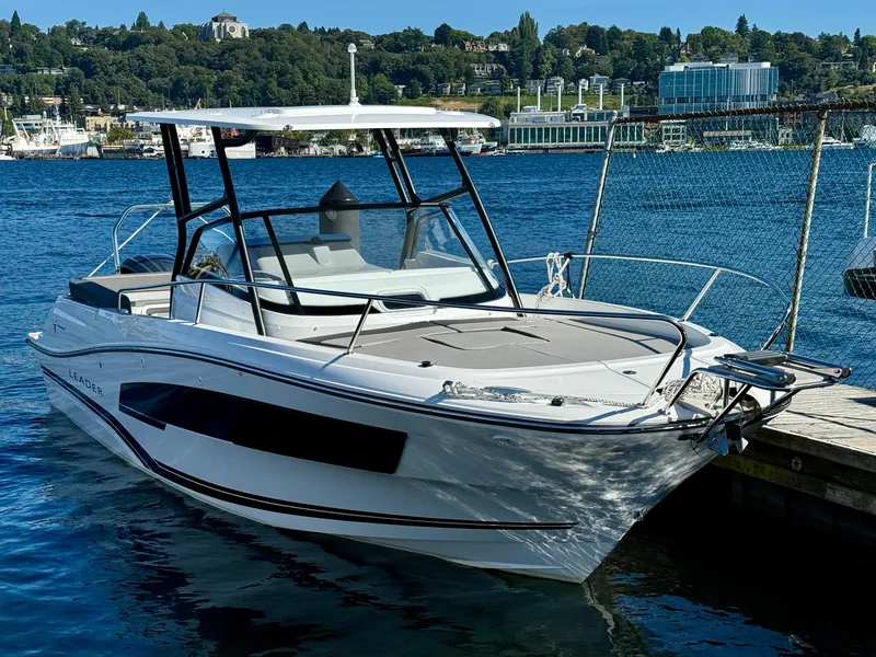 Slide: The Image of 2024 Jeanneau Leader 7.5 WA boat docked on a sunny day, with scenic waterfront background. - 6