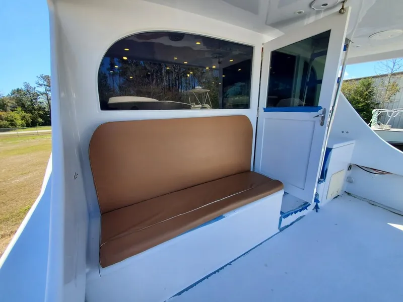 Slide: The Image of 2005 Custom Carolina C 30 CAT boat with brown bench seating and window view. - 14