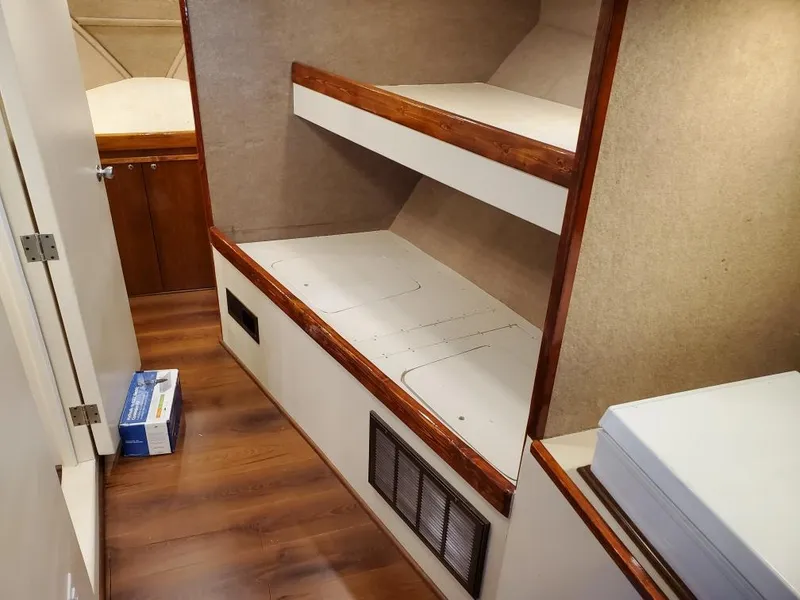 Slide: The Image of Interior of 2005 Custom Carolina C 30 CAT with wooden bunk beds and storage. - 23