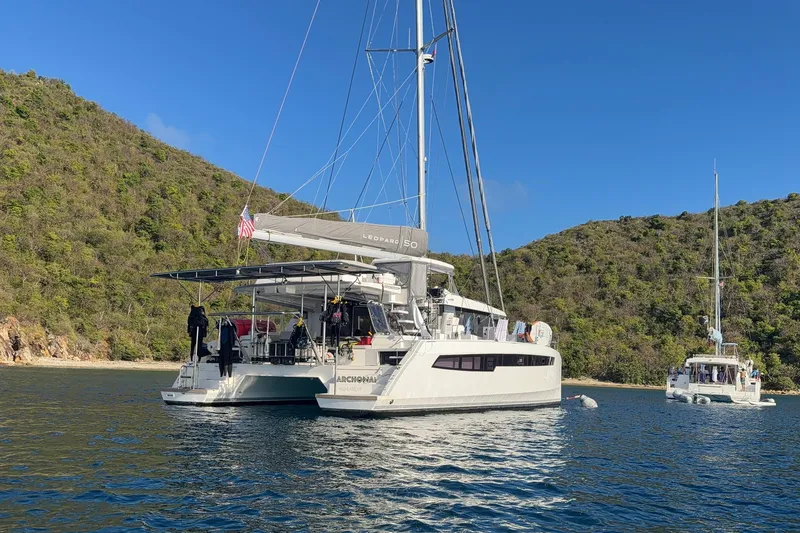 The Image of 2023 Leopard 50 catamaran anchored in scenic bay with lush green hills. - 0