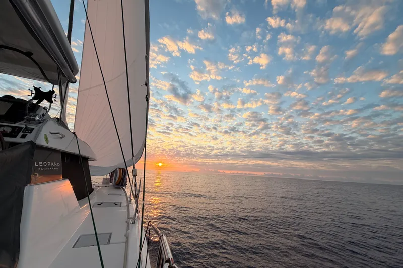 Slide: The Image of Sailing on a 2023 Leopard 50 catamaran at sunset, under a vibrant sky. - 1
