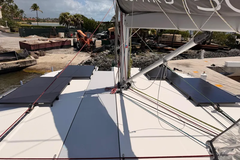 Slide: The Image of 2023 Leopard 50 catamaran docked, featuring solar panels and rigging, with a scenic marina backdrop. - 28
