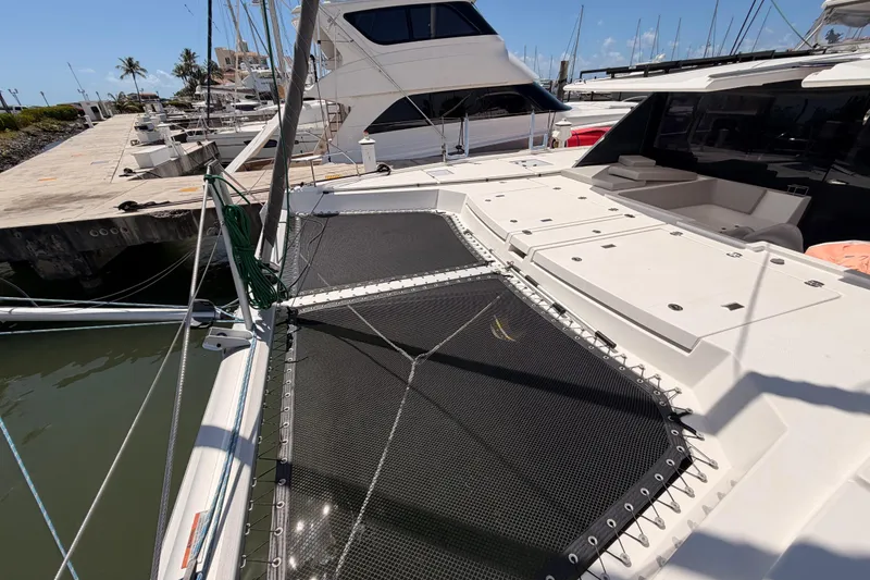 Slide: The Image of 2023 Leopard 50 catamaran docked at marina, featuring spacious deck and netting. - 29
