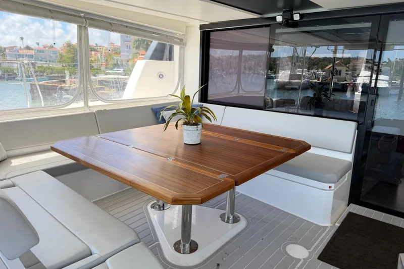 Slide: The Image of Luxurious Leopard 50 yacht interior with wooden table, cushioned seating, and marina view, 2023 model. - 9