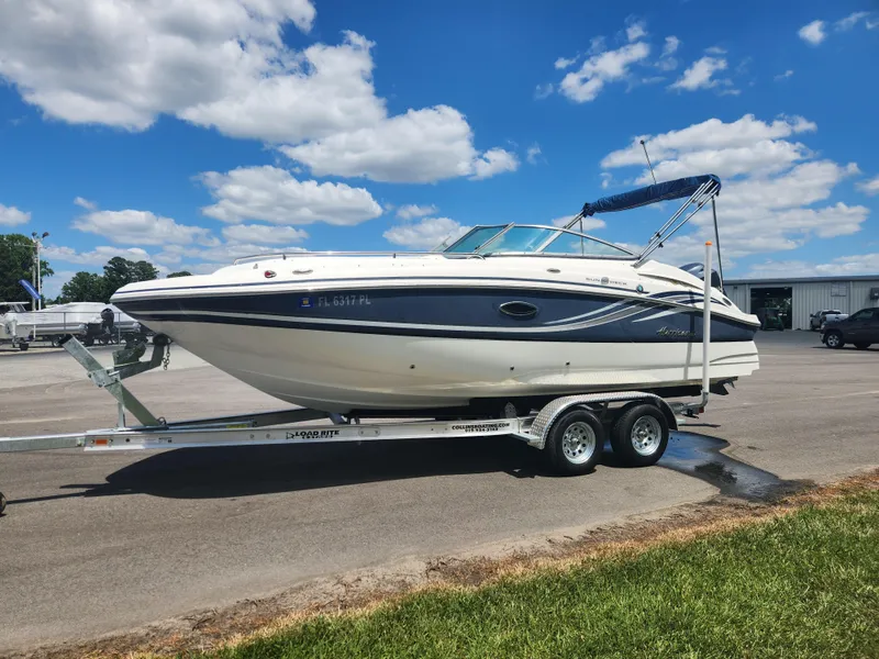 Slide: The Image of 2013 Hurricane SunDeck 2200 OB boat on a trailer under a blue sky. - 4