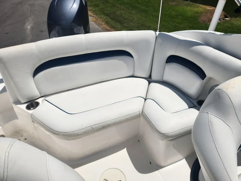 Slide: The Image of 2013 Hurricane SunDeck 2200 OB boat with white and blue cushioned seating. - 8