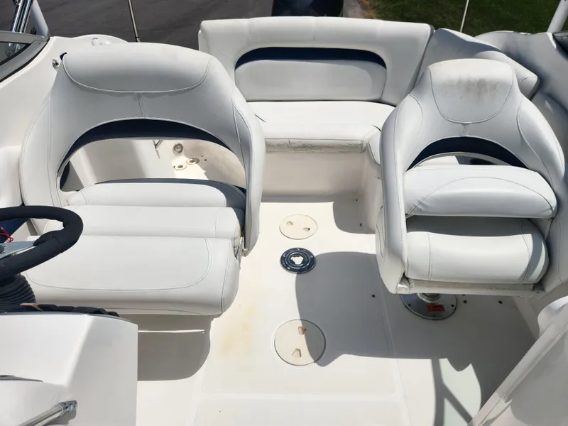 Slide: The Image of 2013 Hurricane SunDeck 2200 OB boat interior with white seating and steering wheel. - 9
