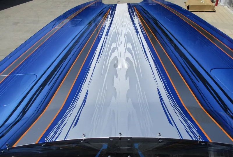 Slide: The Image of Top view of a 2002 Skater 46 boat with blue, white, and orange graphics. - 10