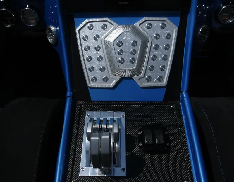 Slide: The Image of Control panel and throttle levers of a 2002 Skater 46 boat. - 2