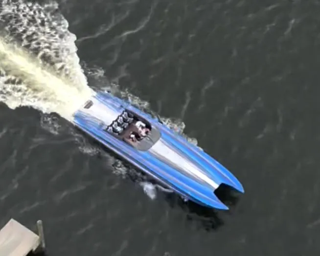 Slide: The Image of Aerial view of a 2002 Skater 46 speedboat cruising on water. - 5