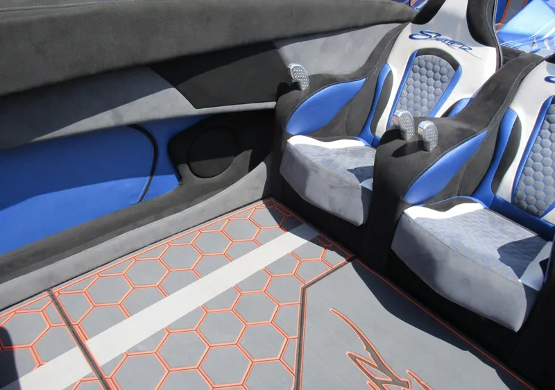 Slide: The Image of Custom interior of a 2002 Skater 46 boat with blue and gray seats and hexagonal floor design. - 6