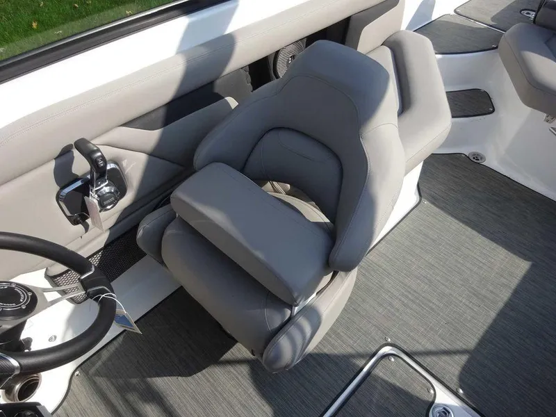Slide: The Image of 2023 Four Winns HD3 boat interior with gray captain's chair and steering wheel. - 14
