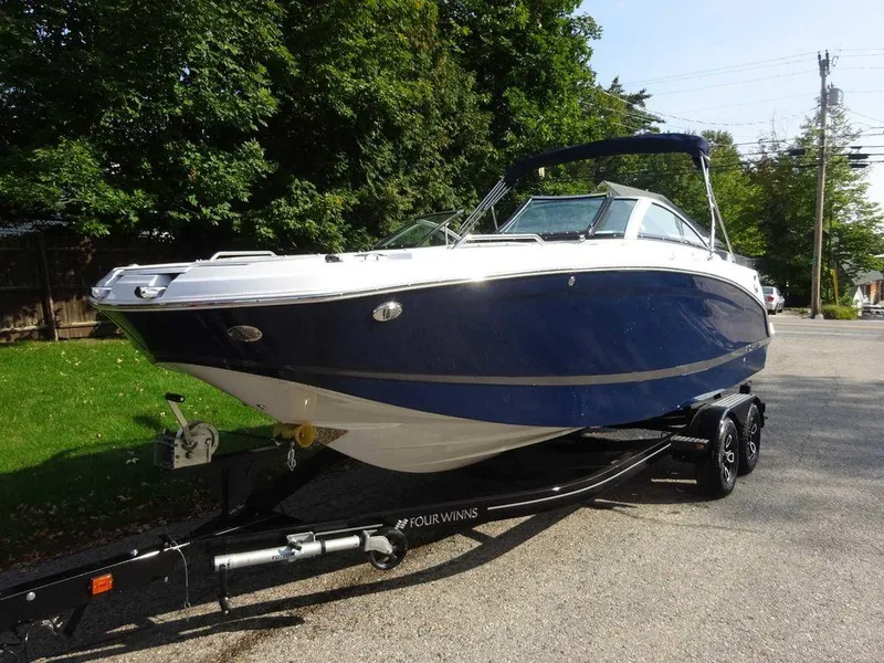 Slide: The Image of 2023 Four Winns HD3 boat on a trailer, parked outdoors. - 22