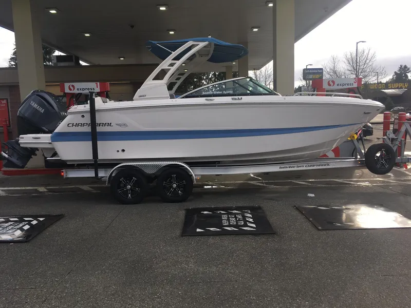 The Image of 2023 Chaparral 250 OSX boat on trailer at a gas station. - 0