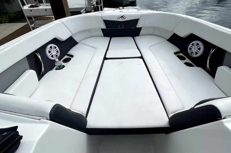 Slide: The Image of 2022 Monterey M225 boat with spacious white seating and built-in speakers. - 13