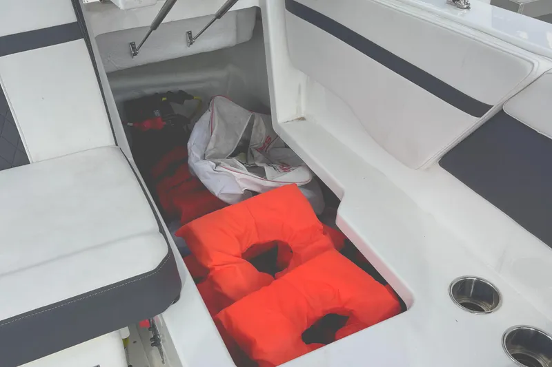 Slide: The Image of 2022 Monterey M225 boat interior with life jackets and storage area. - 21