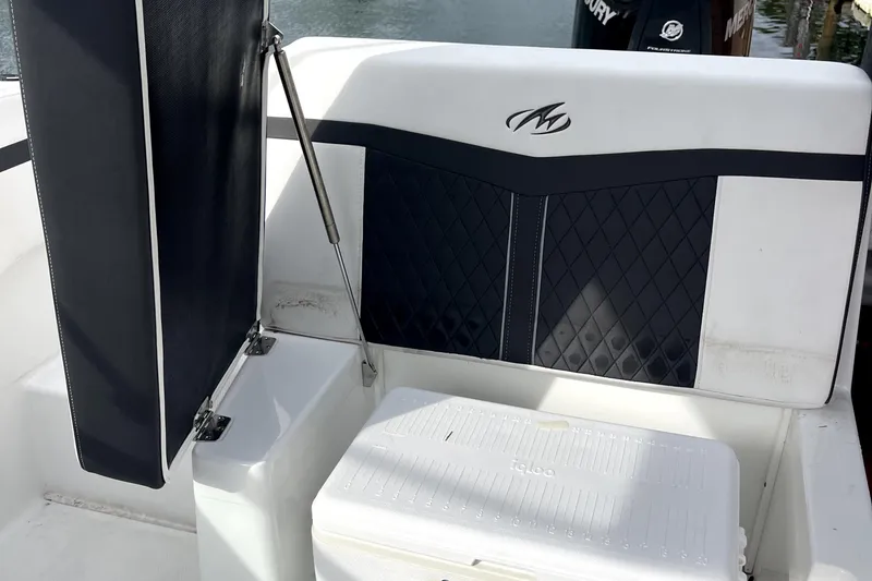 Slide: The Image of 2022 Monterey M225 boat interior with cushioned seating and storage compartment. - 23