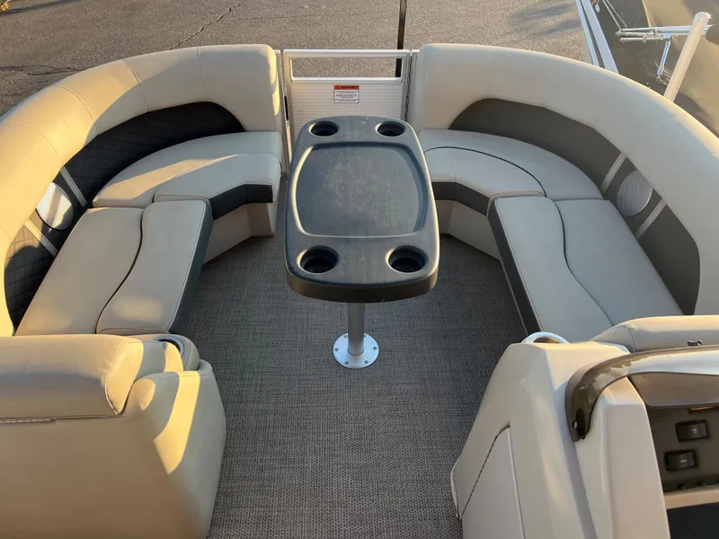 Slide: The Image of 2019 Bennington 22 SSRX pontoon boat interior with beige seating and central table. - 14